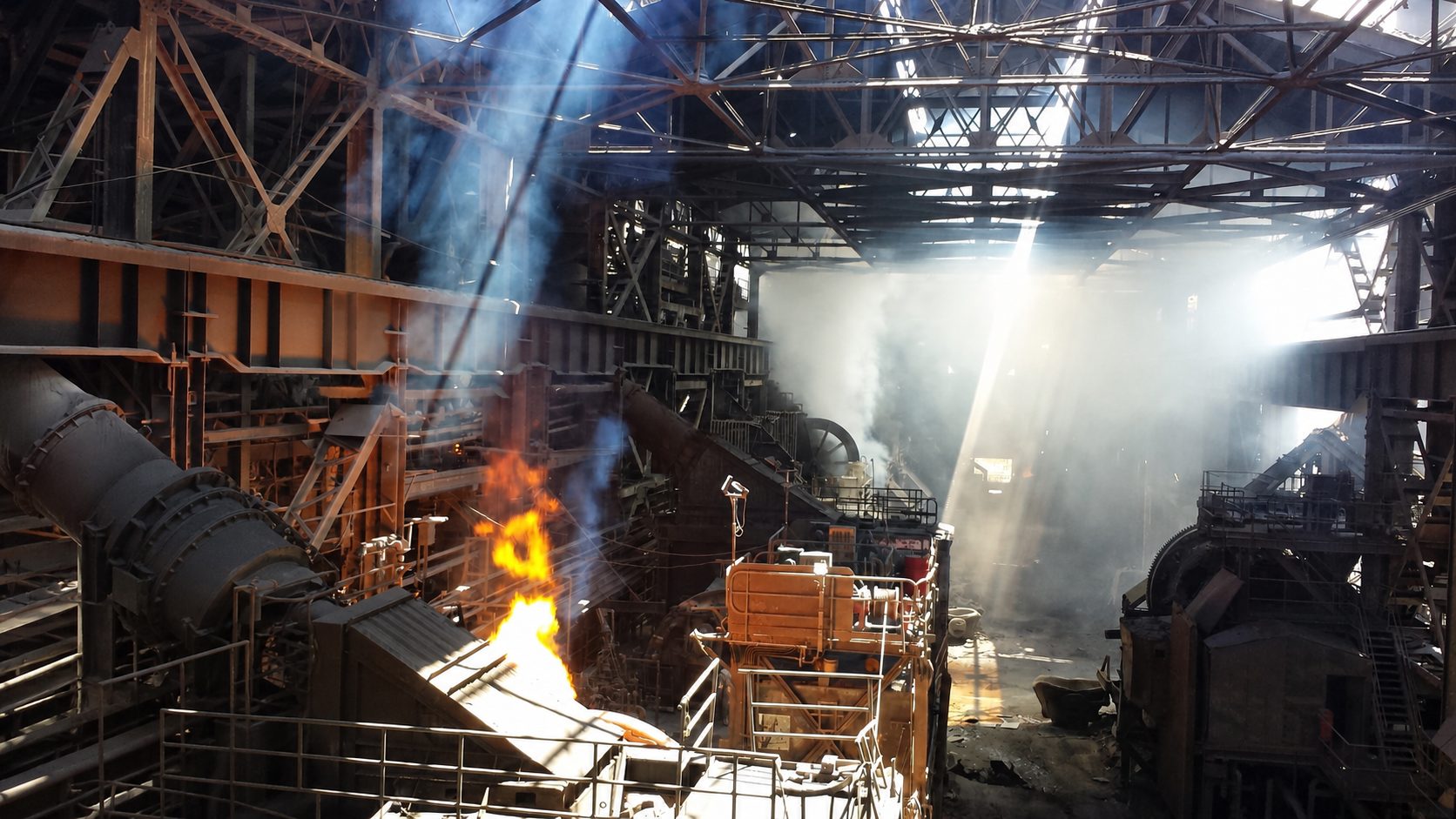 Interior de nave industrial con haces de luz y gases de proceso